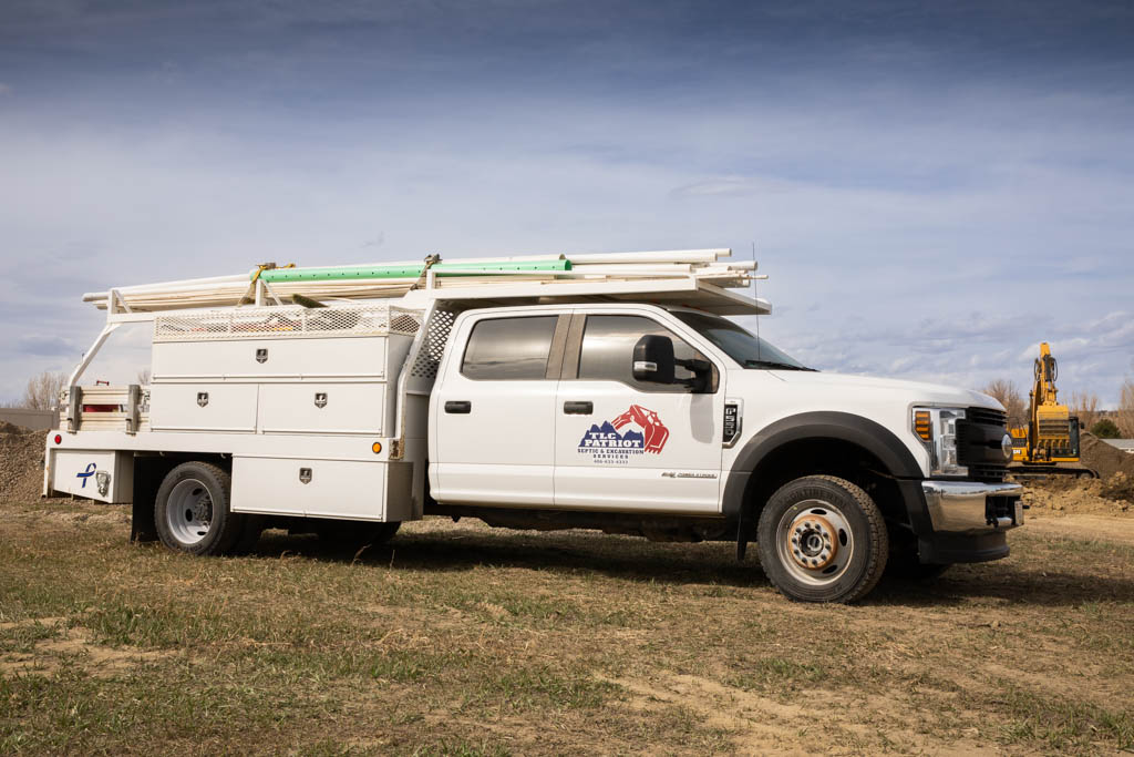 TLC Patriot service truck loaded with pipe on a rural Montana job site