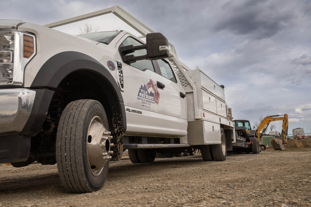 TLC Patriot work truck with a mini excavator on a job site